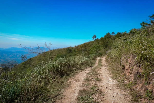 dirt road side / dirt road field on hill to mountain - Rural dusty countryside road trough for off road truck