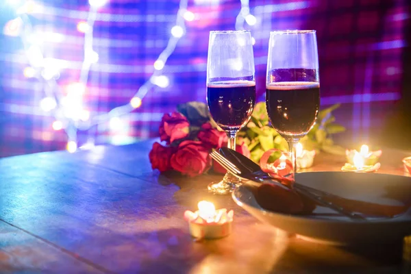 Valentines dinner romantic love concept / Romantic table setting decorated with fork spoon on plate and couple champagne glass roses with candlelight on wooden table dinner night light background — Stock Image Valentines Dinner Romantic Love Concept Romantic Table Setting Decorated Fork Royalty Free Stock Photos
