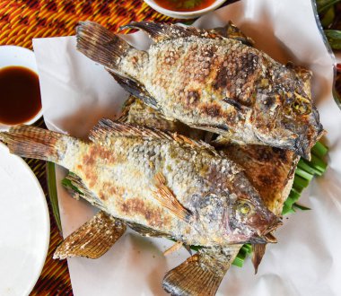 Izgara tuz ile ot tilapia balık ve balık biber sosu Asya Tay tarzında pişmiş plaka üzerinde yanık