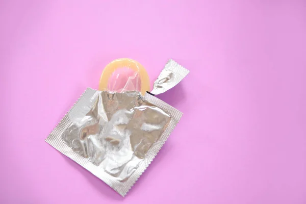 Condom Prevent Pregnancy Contraception safe sex concept / Birth Control with condom in package on pink background -  pregnancy or sexually transmitted disease