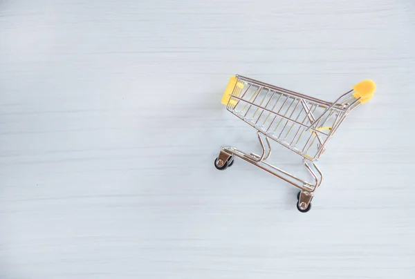 Shopping cart on white wood background / Online shopping Black Friday concept with yellow Shopping cart on top view