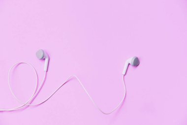 Earphons üzerinde arka plan pembe / müzik benim hayat ve eğlence dinle üstten görünüm üzerinde beyaz kulaklık ile müzik konsepti 
