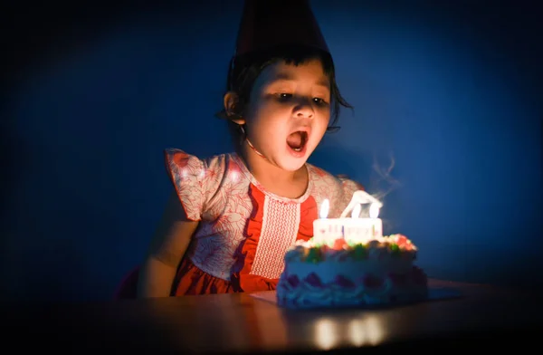 アジア子供の誕生日ケーキのろうそくを吹き 小さなかわいい女の子幸せな誕生日パーティー 夜の肖像画 — ストック写真