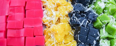 Renkli Tay tatlı arka plan ile pembe klas şekerleme, siyah ve yeşil Hindistan cevizi rendelenmiş puding, buğulanmış manyok sarı - kek jöle arka plan üzerinde katman