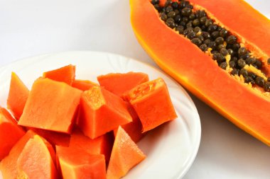 Papaya dilim plaka ve olgun papaya meyve kesme yarısı beyaz arka plan üzerinde incelemek 