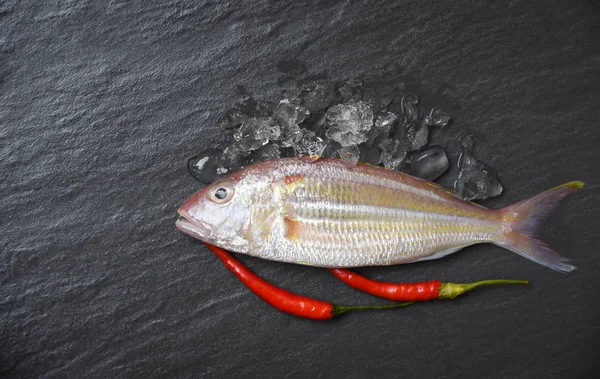 Fresh raw fish on ice dark background / Seafood fish ocean gourmet for cook with red chilli in the restaurant