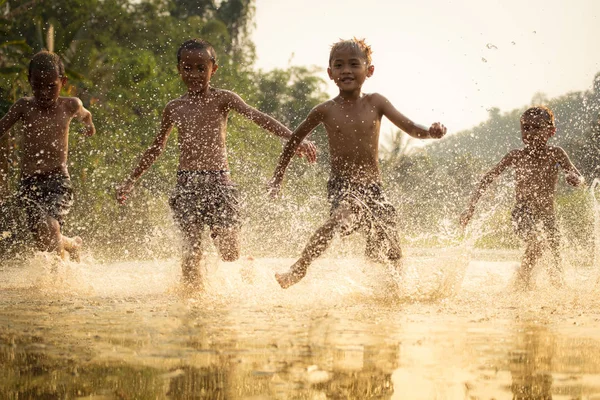 Asia children on river / The boy friend happy funny playing running in the water in countryside of living life kids farmer rural people