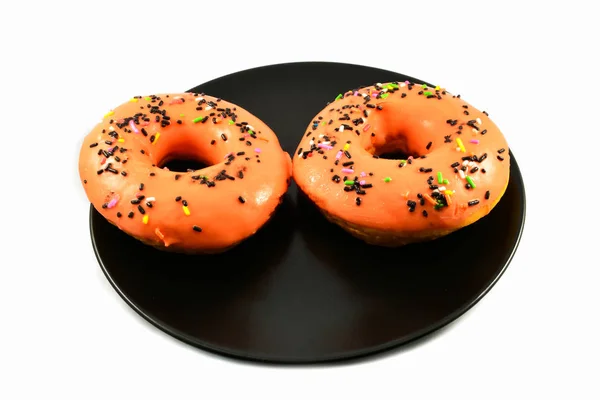 Oranje Donuts Met Hagelslag Zwarte Plaat Witte Achtergrond — Stockfoto