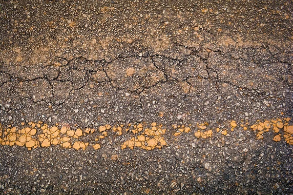 Crack asphalt old road texture background with yellow line