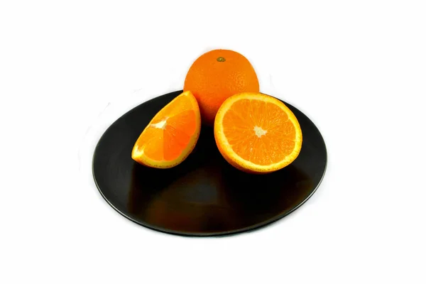 Rebanada de fruta naranja fresca en placa negra aislada en backgro blanco —  Fotos de Stock