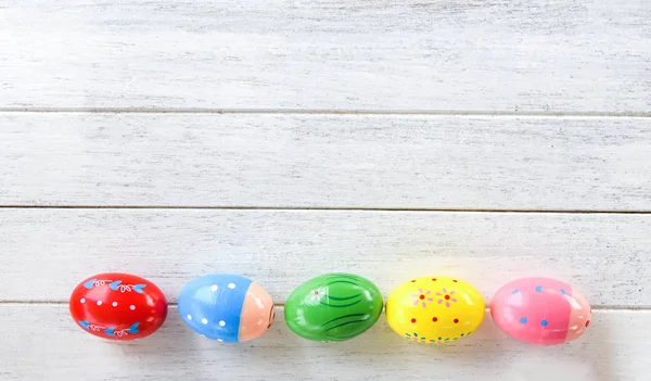 Huevos de Pascua decoración colorida sobre fondo de madera blanca v — Foto de Stock