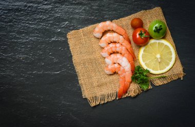 Kabuklu deniz ürünleri taze karides karides deniz ürünleri domates limonlu çuval üzerinde