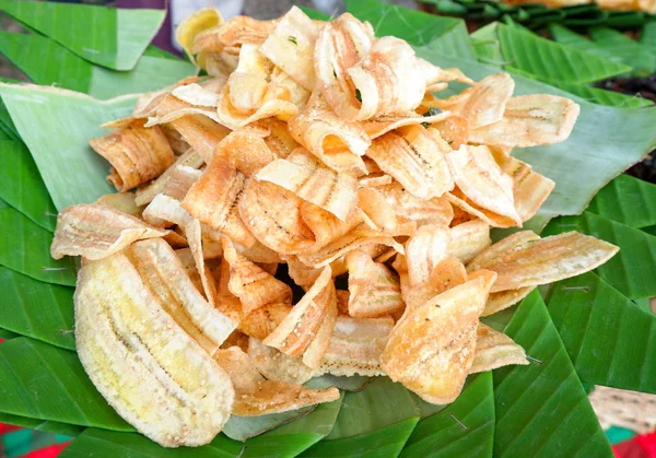 Rebanada de plátano frito crujiente con azúcar sobre fondo de hoja de plátano — Foto de Stock