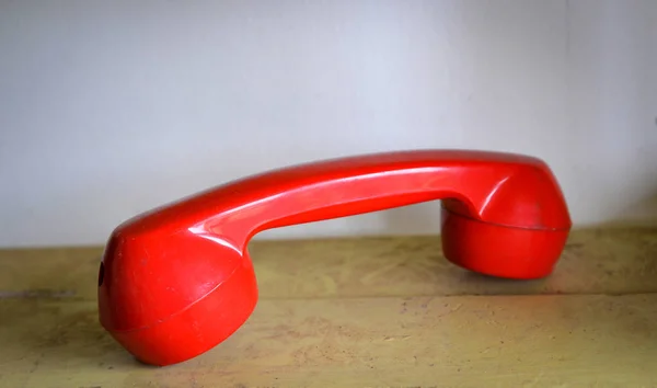 Retro telefono rosso / vecchio ricevitore di telefono rosso sul tavolo di legno in di — Foto Stock