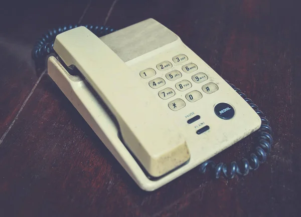 โทรศัพท์เก่าบนโต๊ะไม้ในออฟฟิศ สไตล์โทนโบราณ — ภาพถ่ายสต็อก