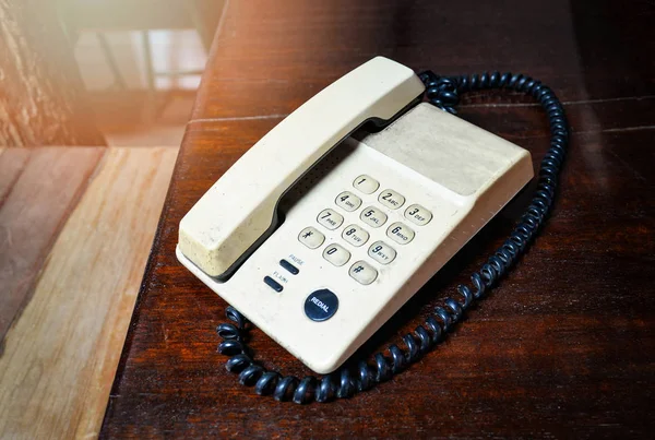 โทรศัพท์เก่าบนโต๊ะไม้ในออฟฟิศ สไตล์โทนโบราณ — ภาพถ่ายสต็อก