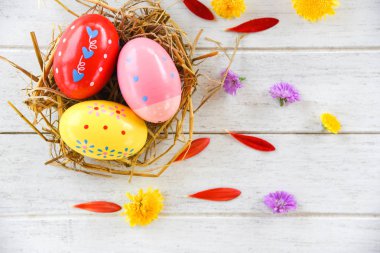 Paskalya yumurtaları ile renkli çiçek petal üzerinde bir yuva dekorasyonda 