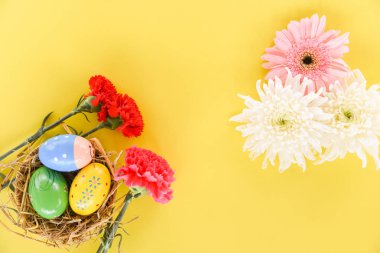 Paskalya yumurtaları sepet içinde kırmızı karanfil çiçek dekorasyon iç içe 