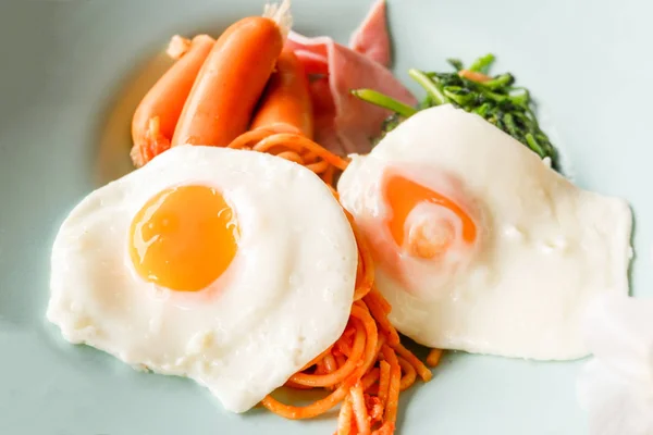 Breakfast fried egg sausage and spaghetti on plate — Stock Photo, Image