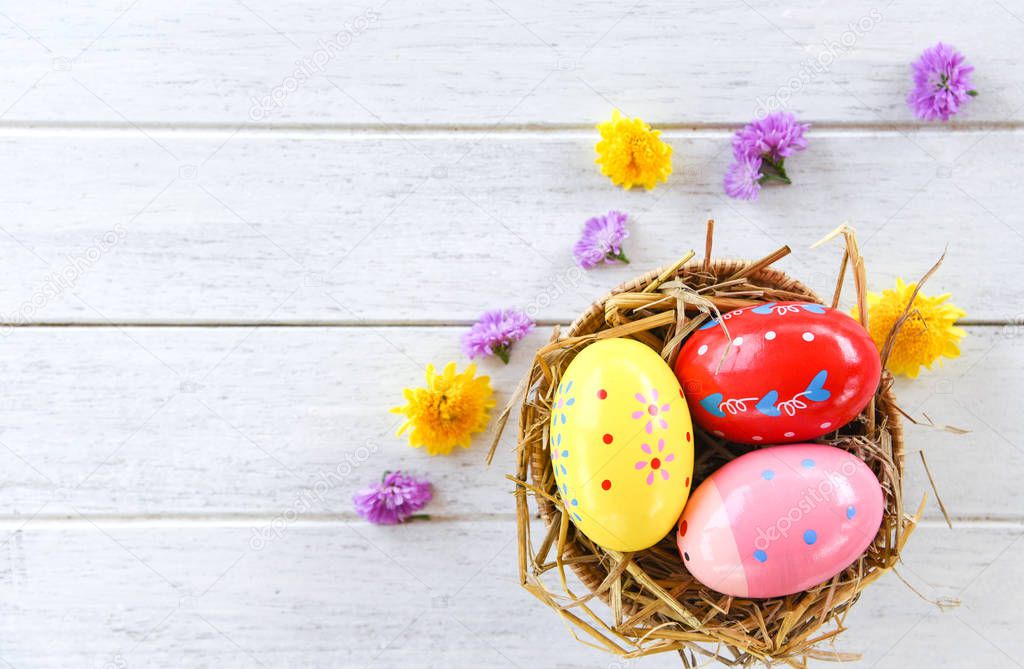 Easter eggs in basket nest decoration with colorful flower sprin