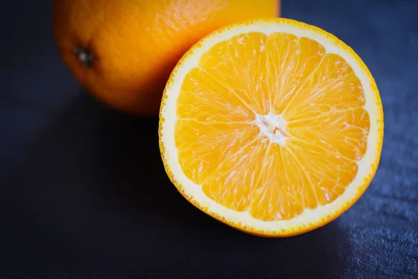 Fatia de fruta laranja fresca metade no fundo escuro — Fotografia de Stock