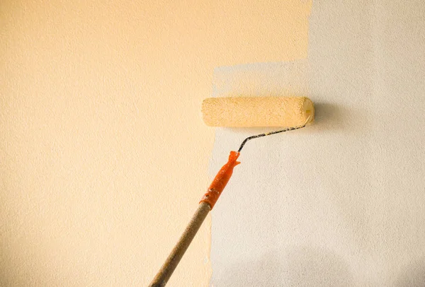 Hand painting wall background with paint roller on building cons — Stock Photo, Image