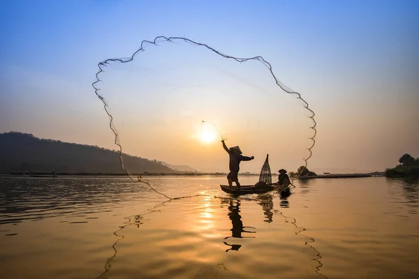 Asia fisherman net using on wooden boat casting net sunset or su — Stock Photo, Image