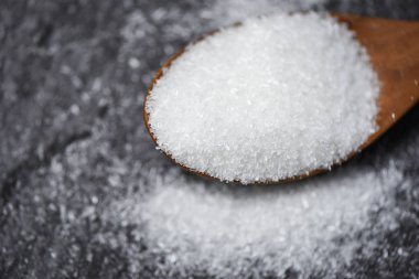 Siyah arka plan ile ahşap kaşık üzerinde MSG/monosodyum glutamat