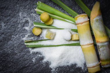 Beyaz şeker ve yeşil yaprak kesilmiş şeker kamışı parçası koyu b