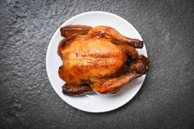 Kızarmış tavuk/pişmiş bütün tavuk beyaz plaka üzerinde ızgara ve