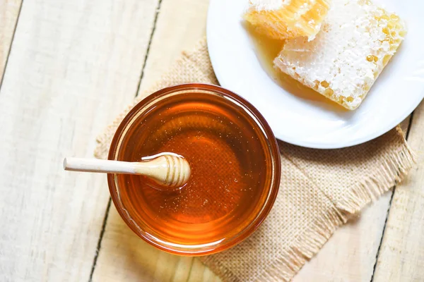Miel dulce fresca en tarro con tarro de madera y panal en whi — Foto de Stock