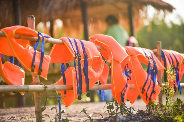 Разноцветное оборудование для безопасности спасательных жилетов на бамбуковых рельсах — стоковое фото