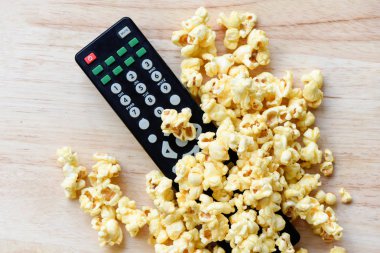 Ahşap masa backgr sinema konsepti patlamış mısır ve uzaktan kumanda