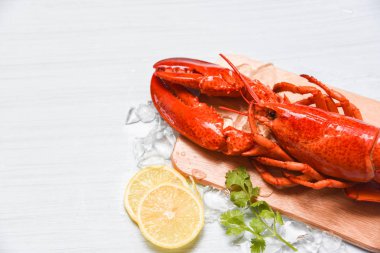 Ahşap kesme tahtası ve limon cori üzerinde buz ile ıstakoz deniz ürünleri