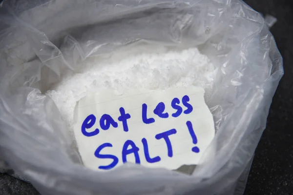 Eat less salt for health concept / Heap of salt in plastic bag b — Stock Photo, Image