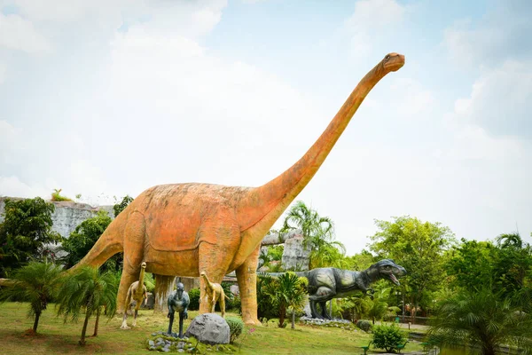 Dinosauriepark / olika arter dinosaurie staty i handflatan tr — Stockfoto
