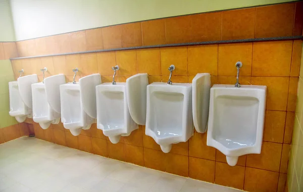 Row of urinal toilet blocks for man in tiled wall in public toil — Stock Photo, Image