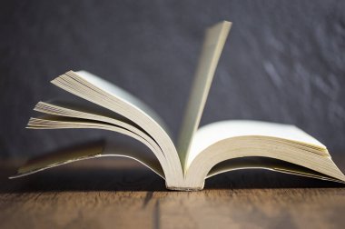 kütüphanede eski ahşap masa koyu arka plan açık kitap vintage