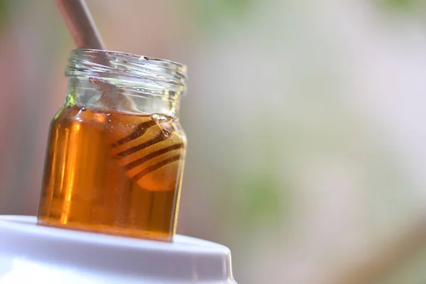 Alimento saludable miel / Primer plano de miel dulce amarilla en frasco con —  Fotos de Stock