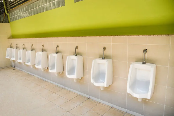 Row of urinal toilet blocks for man on tiled wall in public toil — Stock Photo, Image