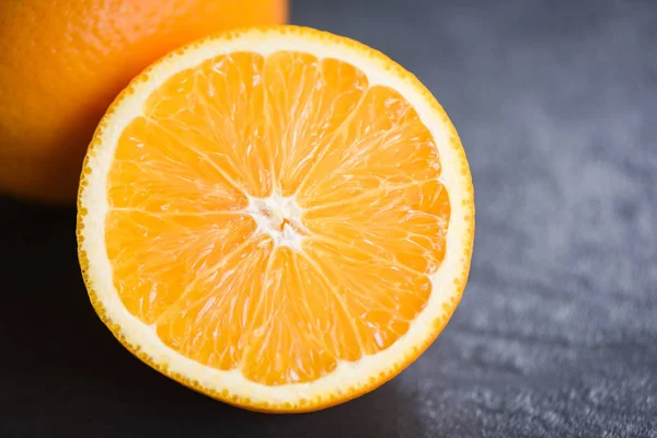 Rebanada de fruta naranja fresca mitad sobre fondo oscuro —  Fotos de Stock