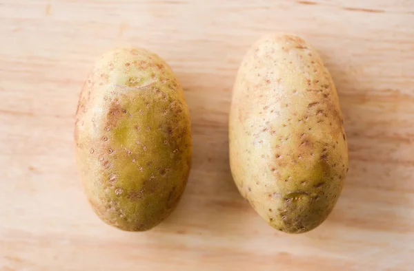 Čerstvé surové brambory na dřevěné pozadí — Stock fotografie