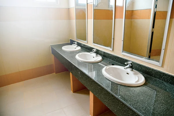 公共のトイレの白い浴室で洗面台と鏡を洗う — ストック写真