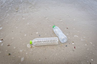 Plaj kumlu kirli denizde plastik şişe ile denizde Çöp 