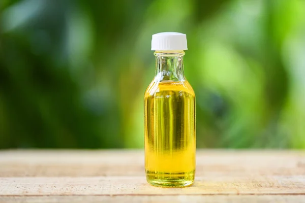 Sesame oil in glass bottles on wooden and nature green — Stock Photo, Image