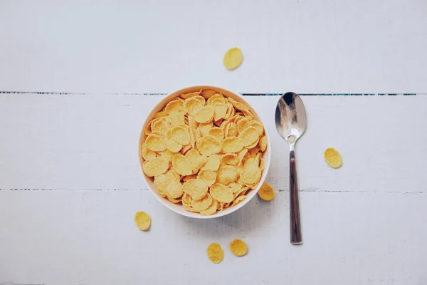 Cornflakes desayuno en tazón y cuchara sobre fondo de madera - ce — Foto de Stock