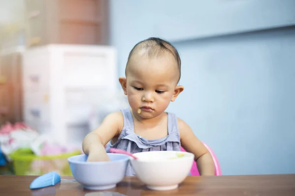 Child eats itself healthy food - Asian baby eating lunch food po — Stock Photo, Image