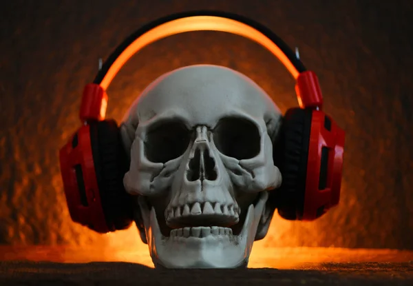 Totenkopf-Musik mit Kopfhörer / menschlicher Schädel hört Musik-Ohr — Stockfoto