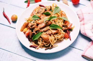 Sıcak ve baharatlı spagetti makarna domates biber ve fesleğen üst yaprakları