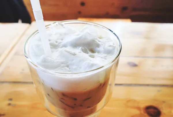 Ledová káva s mlékem ve skle na stole — Stock fotografie